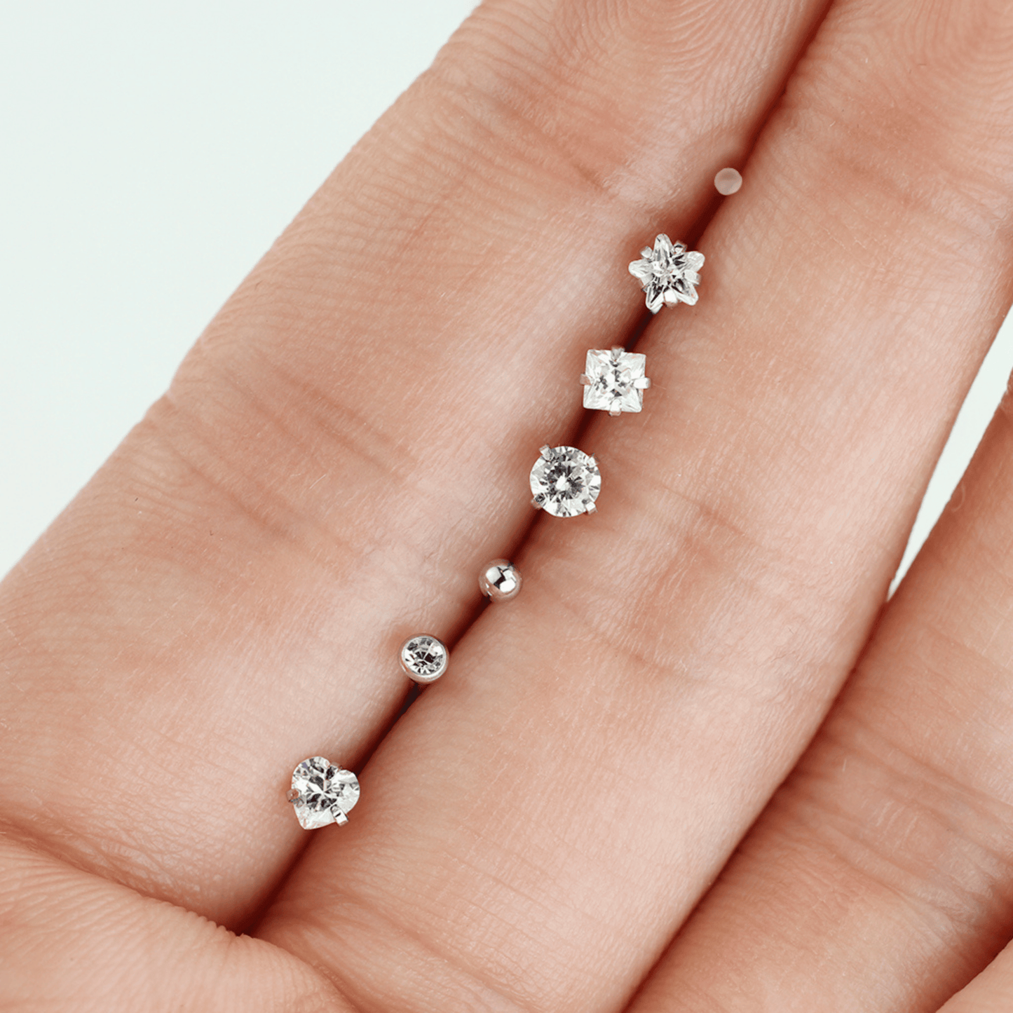 7 Piece Clear Prong Set Gem Nose Bone Studs in hand