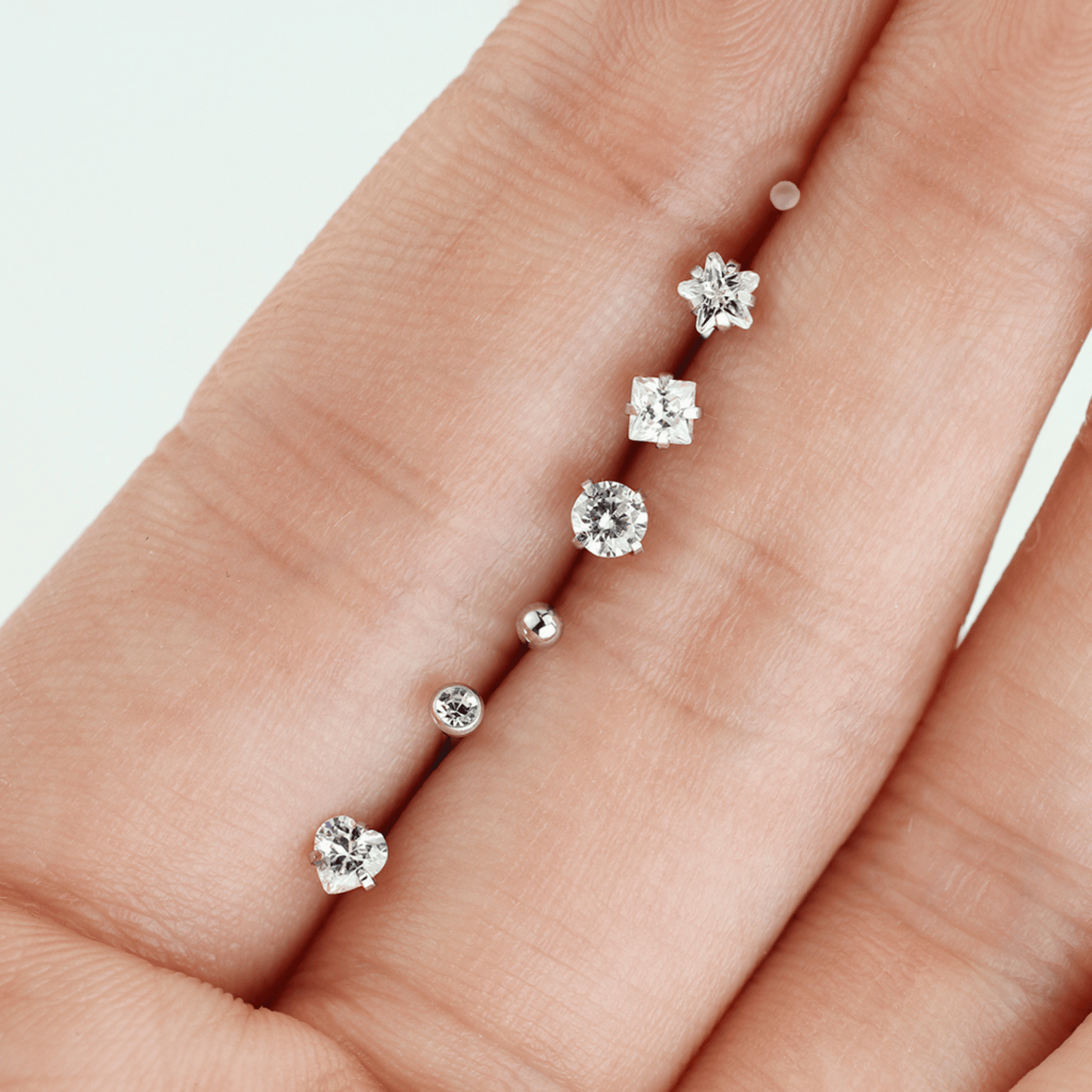7 Piece Clear Prong Set Gem Nose Bone Studs in hand