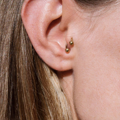 Gold circular horseshoe barbell tragus piercing